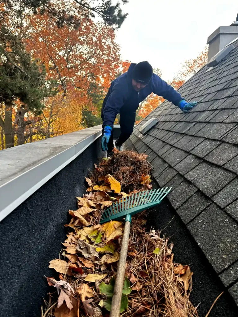 Professional gutter cleaning service in Toronto showing debris removal on a residential roof in North York.